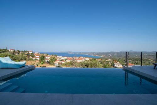a swimming pool with a view of the ocean at Sunset Luxury Villa in Akritokhórion