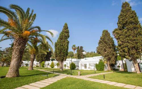 a palm tree in front of a white building at Mövenpick Hotel Gammarth Tunis in Gammarth