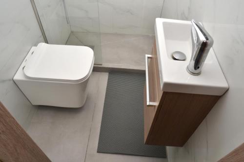 a bathroom with a white toilet and a sink at Διαμέρισμα δίπλα από την θάλασσα in Athens