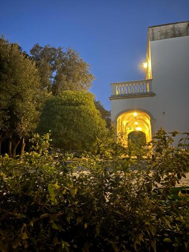 a building with a lit up arch in a garden at Villa Tuzzo in Lecce