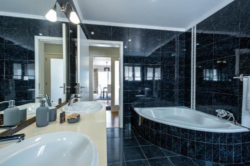 Baño negro con 2 lavabos y bañera en Home Inn Green Caldera, en Furnas