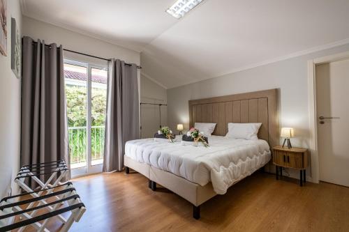 Un dormitorio con una cama grande con flores. en Home Inn Green Caldera, en Furnas