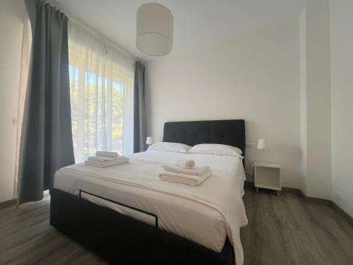 een slaapkamer met een groot bed met handdoeken erop bij Mare Mosso in Bordighera