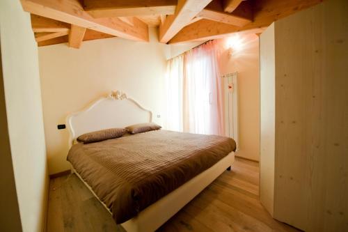 - une chambre avec un lit dans une pièce dotée d'une fenêtre dans l'établissement Residence La Corte, à Vezza dʼOglio