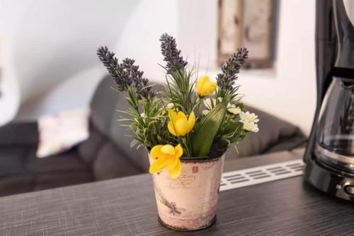 a vase filled with yellow flowers on a table at Greta in Vrbnik