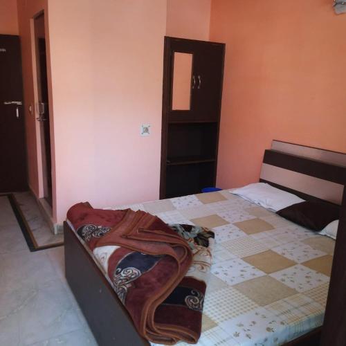 a bedroom with a bed with a checkered floor at Divya Hotel in Rishīkesh