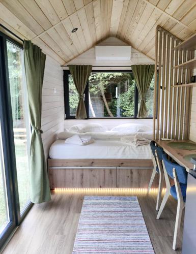 a bed in a small room with a window at Transfăgărășan River Retreat in Arefu