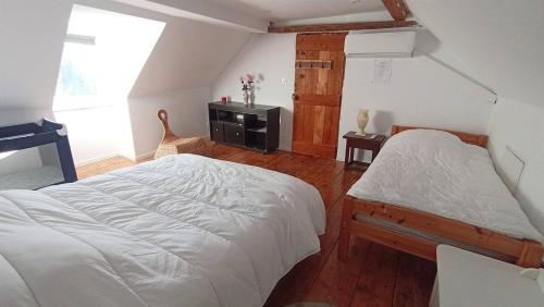 a bedroom with two beds and a window at Maison Plein Soleil in Montauban-de-Luchon
