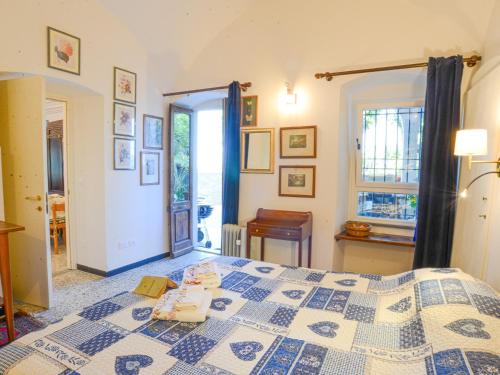 a bedroom with a bed with a blue and white quilt at Villa Angela by Holiday World in Toirano