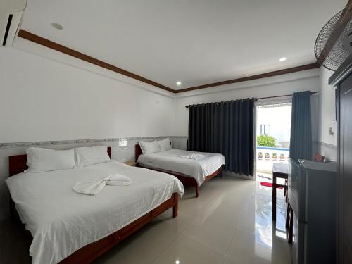 a hotel room with two beds and a balcony at I Hostel Muine - A Little White Homestay By The Sea in Mui Ne