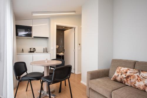 a living room with a couch and a table and chairs at Essence Inn Marianos Hotel in Fátima