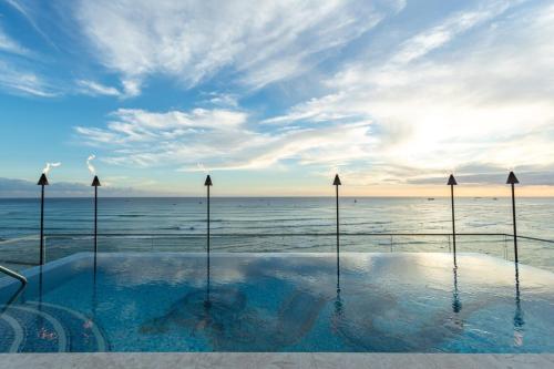 a swimming pool with the ocean in the background at ESPACIO THE JEWEL OF WAIKIKI in Honolulu