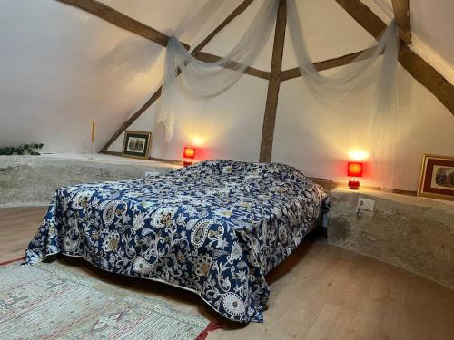 une chambre avec un lit avec une couverture bleue et blanche dans l'établissement Chaumière en Brenne, à Mauvières