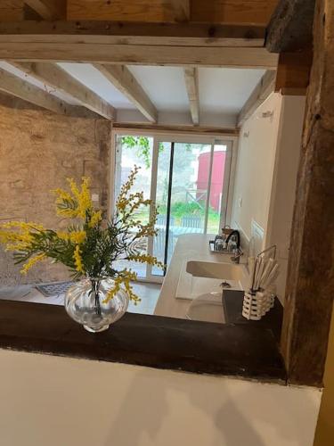 un salon avec un vase de fleurs sur une table dans l'établissement Chaumière en Brenne, à Mauvières