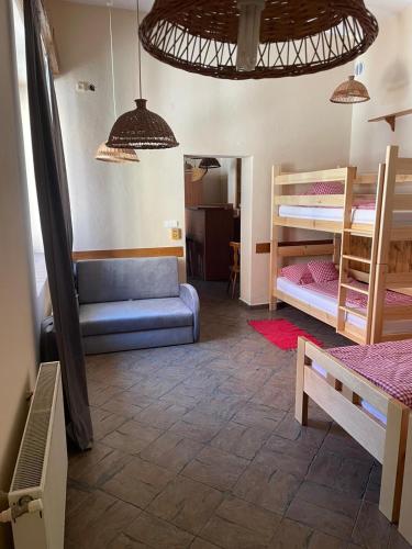a room with two bunk beds and a blue couch at Penzión Duna & soľná jaskyňa in Komárno