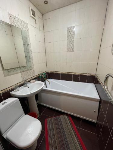 ein Badezimmer mit Waschbecken, Badewanne und Toilette in der Unterkunft Двухкомнатная Квартира 5 in Balqasch