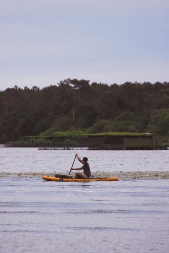 a man sitting on a kayak in the water at Villa de l'Etang Blanc in Seignosse