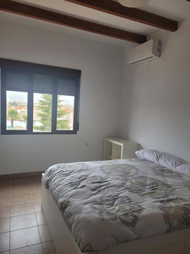 a bedroom with a bed and a window at Casa Rural en Casasimarro in Casasimarro