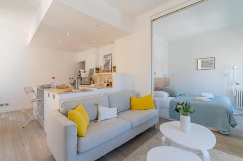 - un salon avec un canapé bleu et des oreillers jaunes dans l'établissement Le Nautica - Première ligne sur le Vieux Port, à Marseille