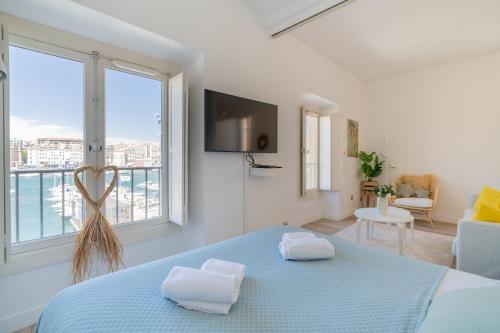 une chambre avec un lit et une grande fenêtre dans l'établissement Le Nautica - Première ligne sur le Vieux Port, à Marseille
