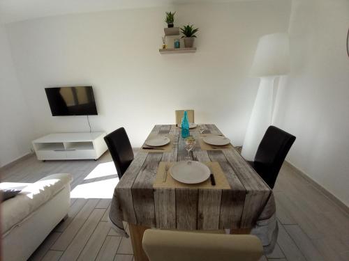 a wooden table in a living room with a couch at Appart T3 avec Cours et Parking Privé in Montélimar