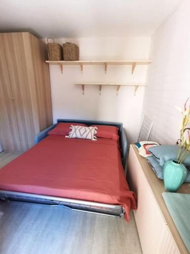 Cette petite chambre comprend un lit avec des draps rouges. dans l'établissement Studio 50m tram parking gratuit 13min gare, à Montpellier
