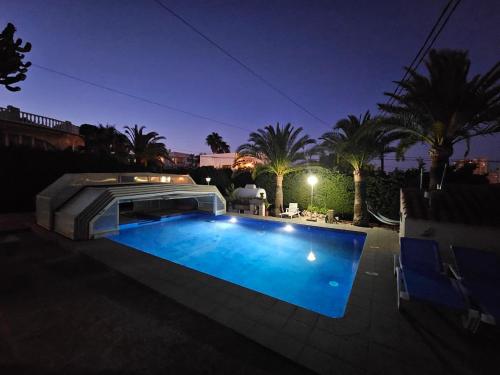 a swimming pool in a yard at night at Chalet Los Almendros con piscina privada in Calpe