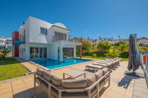 a villa with a swimming pool and lounge chairs at Capetown Marina Luxury Villa - Private Pool in Albufeira
