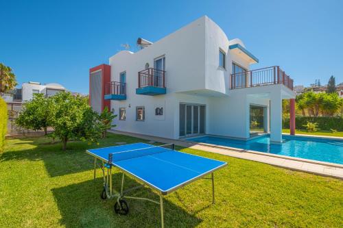 a ping pong table in front of a house with a pool at Capetown Marina Luxury Villa - Private Pool in Albufeira