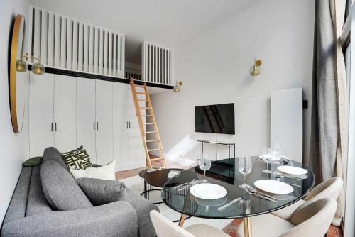 una sala de estar con una mesa y sillas de cristal en Magnifique appt avec 2 salons- 1BD-6P - Notre-Dame, en París