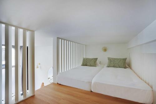 une chambre avec un lit blanc et une grande fenêtre dans l'établissement Magnifique appt avec 2 salons- 1BD-6P - Notre-Dame, à Paris