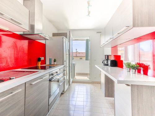 - une cuisine avec des placards blancs et des murs rouges dans l'établissement Apartment Cap Californie by Interhome, à Nice