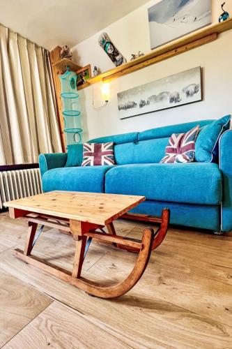 - un salon avec un canapé bleu et une table basse en bois dans l'établissement Studio Le Slalom - Val Claret-5 by Interhome, à Tignes