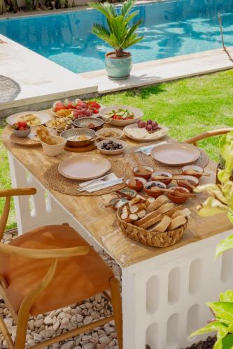 a picnic table with food on it next to a pool at Alacati Fora Bella in Alacati