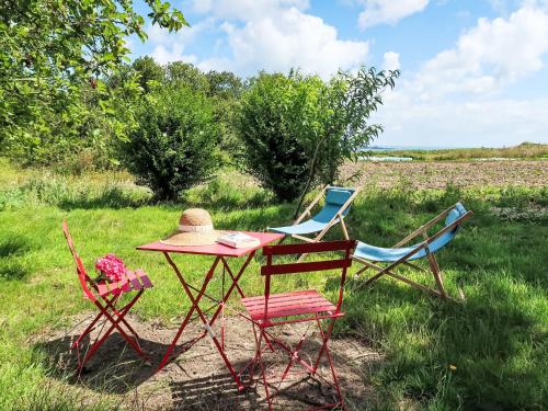 Deux chaises et une table avec un chapeau dans l'établissement Holiday Home Gwenn by Interhome, à Paimpol