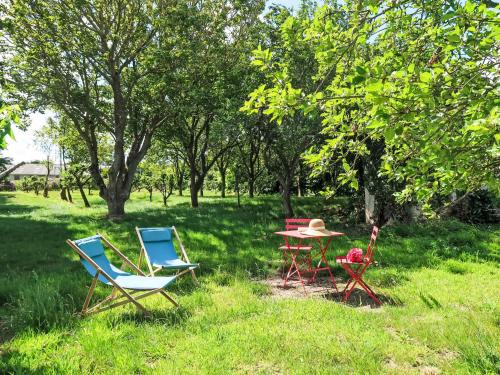 3 chaises et une table dans l'herbe dans l'établissement Holiday Home Gwenn by Interhome, à Paimpol