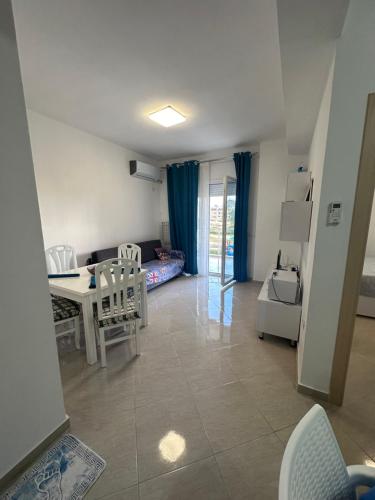Una sala de estar con mesa y sillas y un dormitorio. en Casa vacanze, en Radhimë