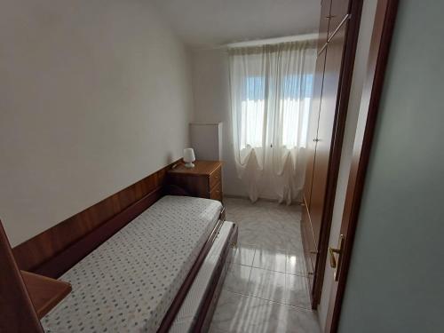 a small bedroom with a bed and a window at Terrazza Oneto in Crocetta