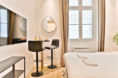 - une chambre avec un lit, une table et deux chaises dans l'établissement Studio Chic au centre du sentier Paris, à Paris