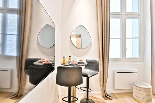 - une salle à manger avec une table et deux miroirs dans l'établissement Studio Chic au centre du sentier Paris, à Paris