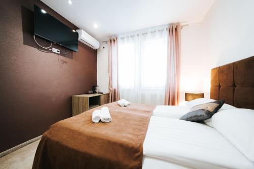 a hotel room with two beds and a flat screen tv at Old Town Residence Rooms in Sarajevo