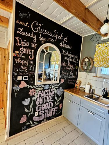 a kitchen with a chalkboard wall with writing on it at GłuszaSpot Dom Freja in Bytoń