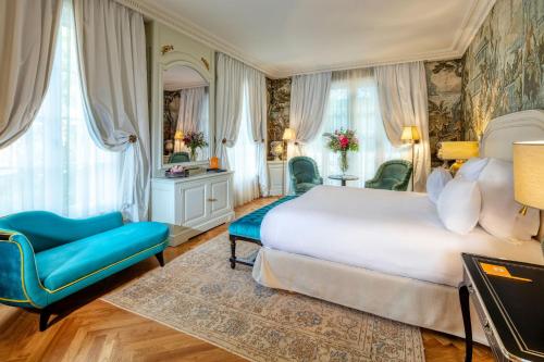 a bedroom with a large bed and a blue chair at Villa Saint-Ange in Aix-en-Provence