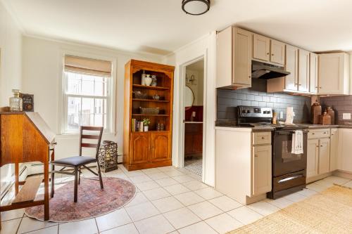 セーラムにあるMoody Salem Home Away From Homeの白いキャビネット、テーブル、椅子付きのキッチン