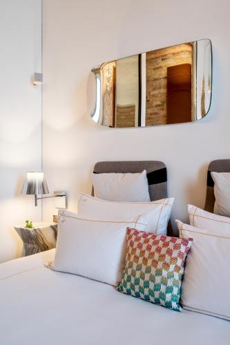 a bedroom with a white bed with a mirror on the wall at The Joseph in Vilnius