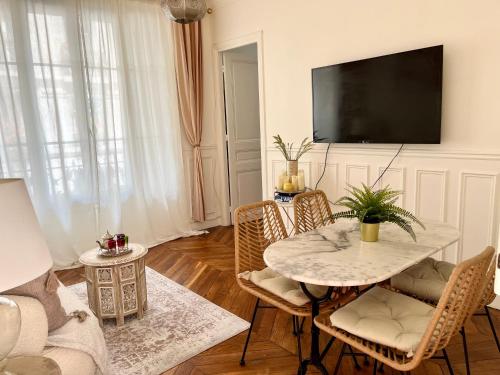 - un salon avec une table, des chaises et une télévision dans l'établissement Appt de charme - Paris 15 eme, à Paris