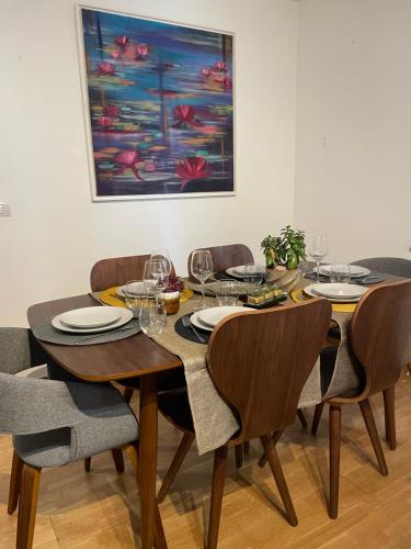 une table à manger avec des chaises et un tableau dans l'établissement Superbe appartement, 1er étage avec ascenseur, à 5 min du métro avec parking gratuit, au Kremlin-Bicêtre