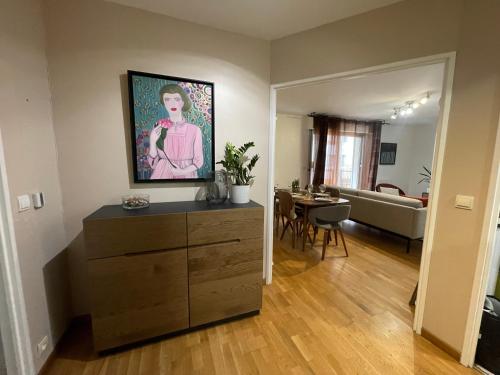 - un salon avec une commode ornée d'une peinture murale dans l'établissement Superbe appartement, 1er étage avec ascenseur, à 5 min du métro avec parking gratuit, au Kremlin-Bicêtre
