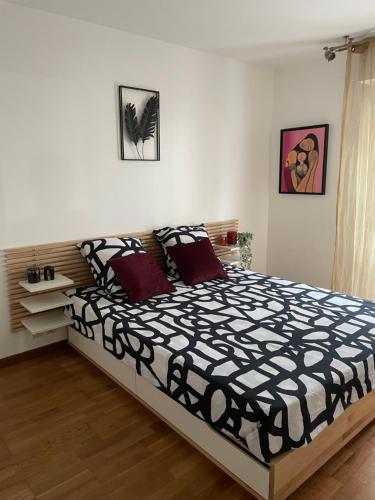 une chambre avec un lit avec une couette noire et blanche dans l'établissement Superbe appartement, 1er étage avec ascenseur, à 5 min du métro avec parking gratuit, au Kremlin-Bicêtre