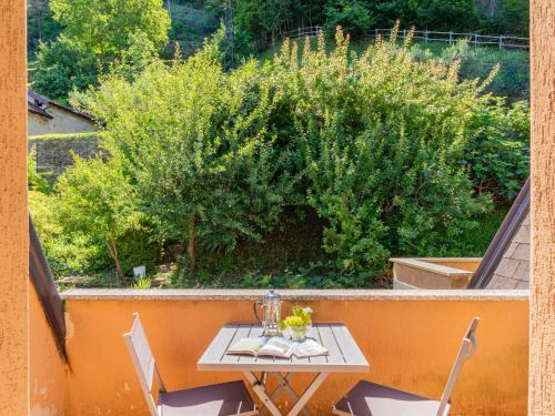 a table and chairs on a balcony with a bush at Apartment Vento Errante by Interhome in Dorio